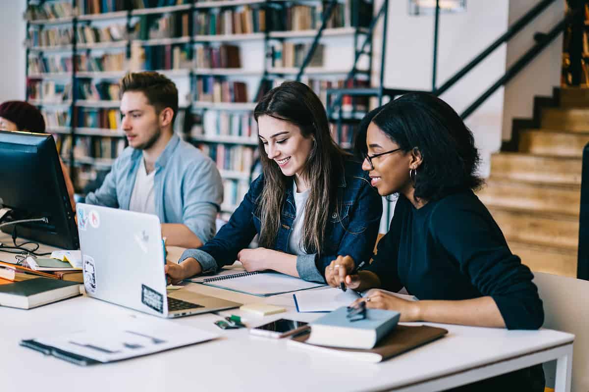 University students having a discussion in the library.