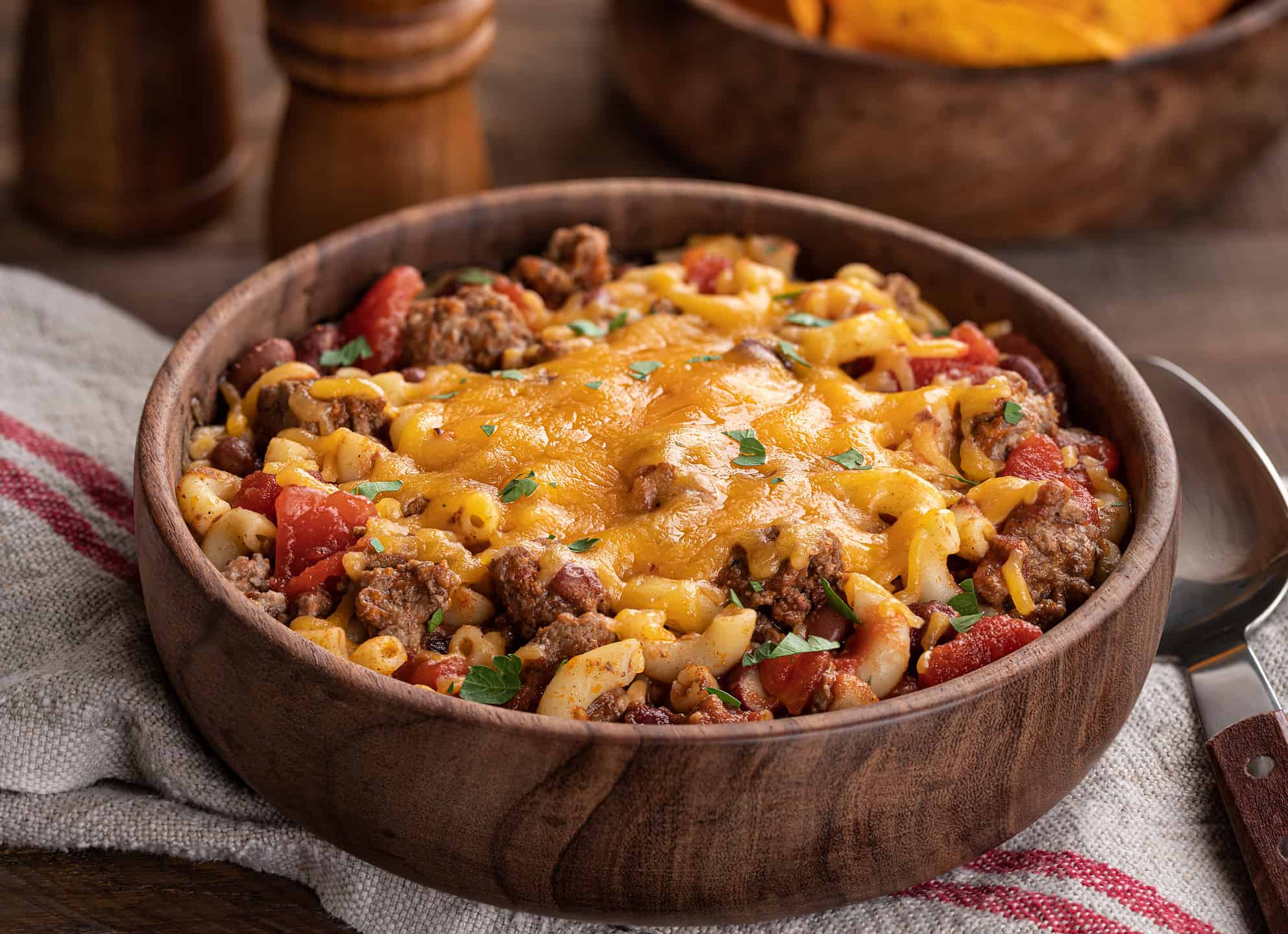 Bowl of chili macaroni with cheddar cheese