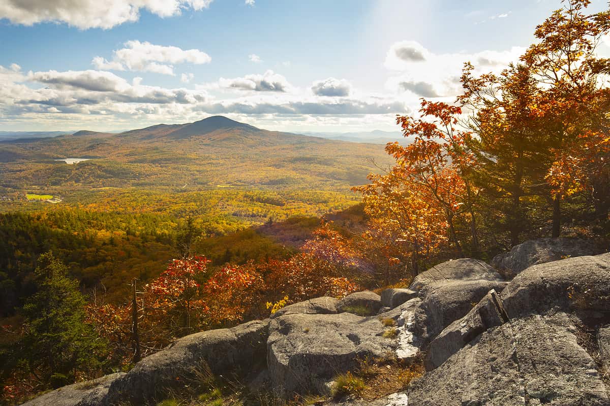 Fall view from Ragged Mountain of Mt. Kearsarge in the distance, with fall foliage and granite ledges in Andover, New Hampshire.