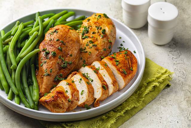 Oven baked boneless chicken breast made with paprika and parsley, green beans. Healthy eating concept.