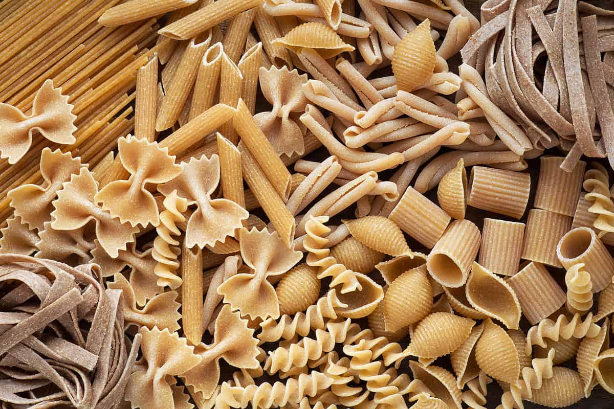 Variety of types and shapes of wholemeal pasta. Dry integral pasta background