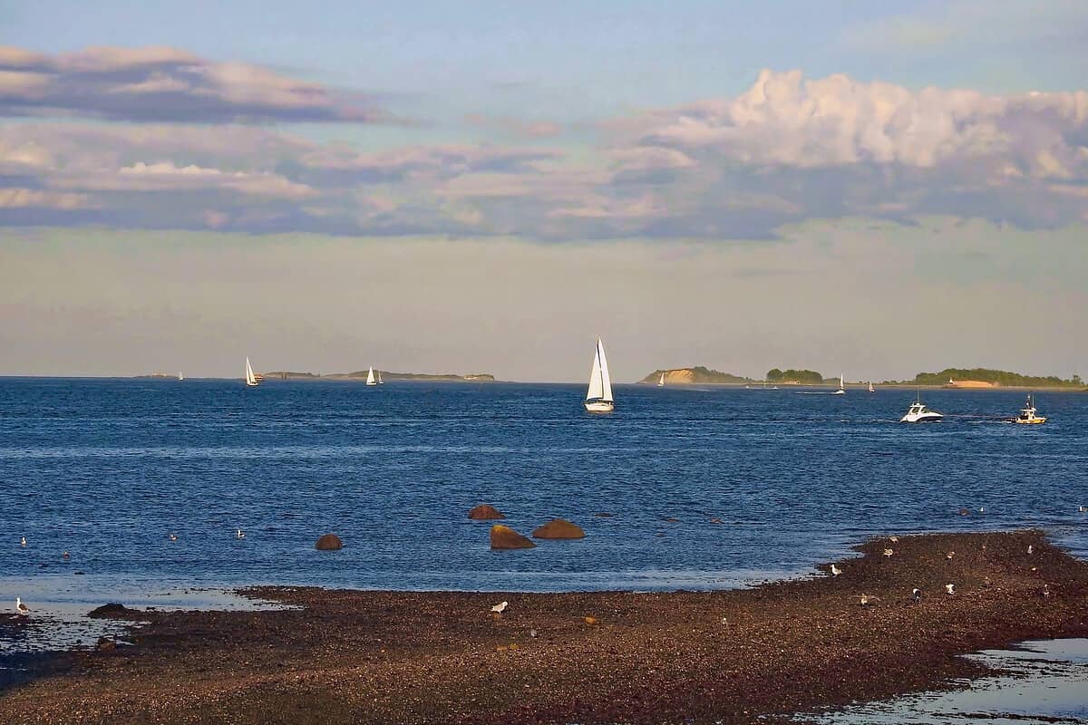 Sailboats sailing in Boston Harbor as seen from Castle Island in Boston, Massachusetts.