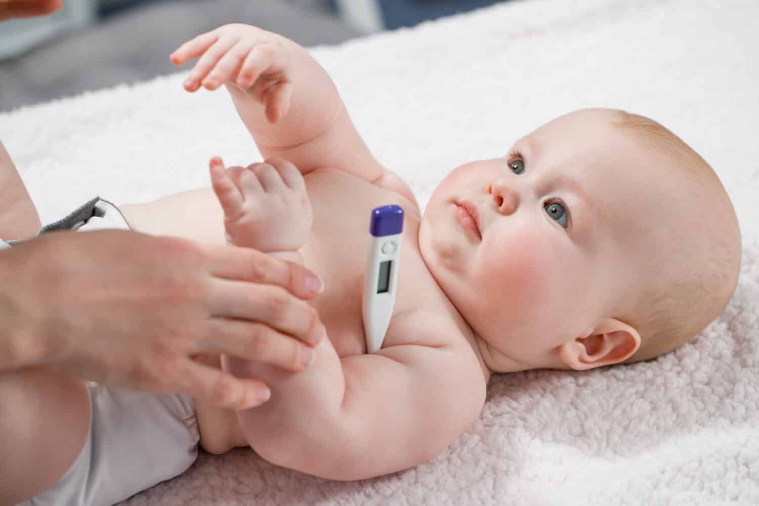 Woman measuring temperature of small sick boy