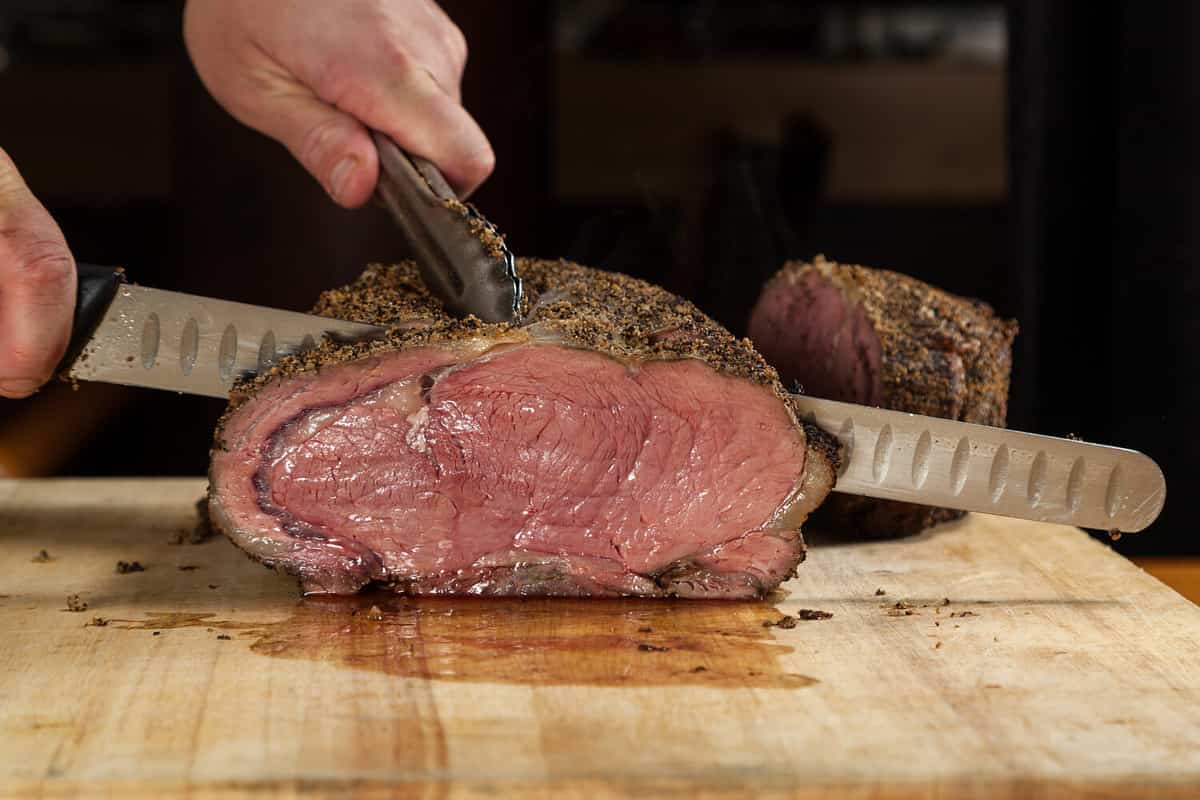 Close up of a large Prime rib roast being sliced for dinner service