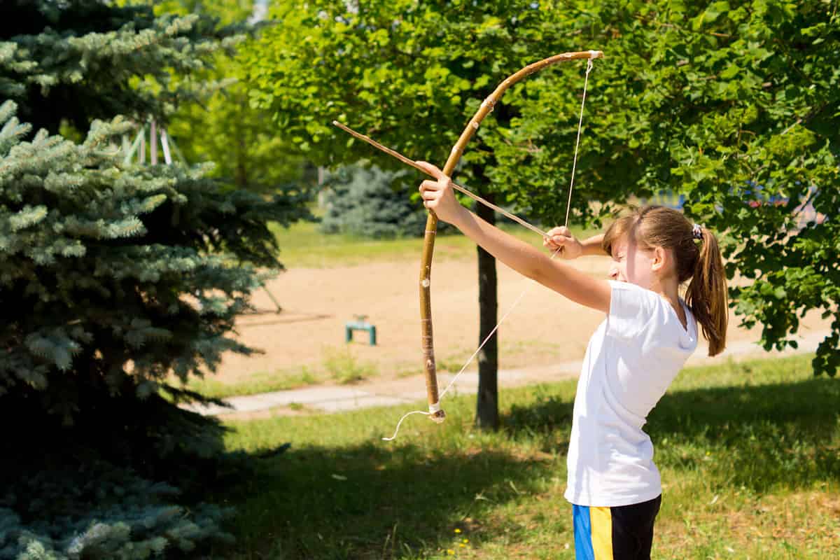Girl practising outdoors with a arch and arrow