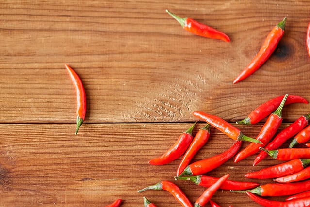 cooking, food and culinary concept - red chili or cayenne pepper on wooden boards