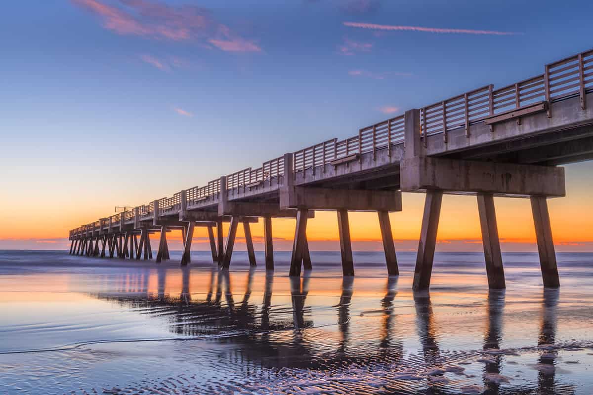 Jacksonville, Florida, USA beach view with Jacksonville Pier at dawn.