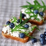 Selective focus. Cottage cheese toast with blueberries and arugula. The keto diet. Keto toast. Bruschetta with cottage cheese.