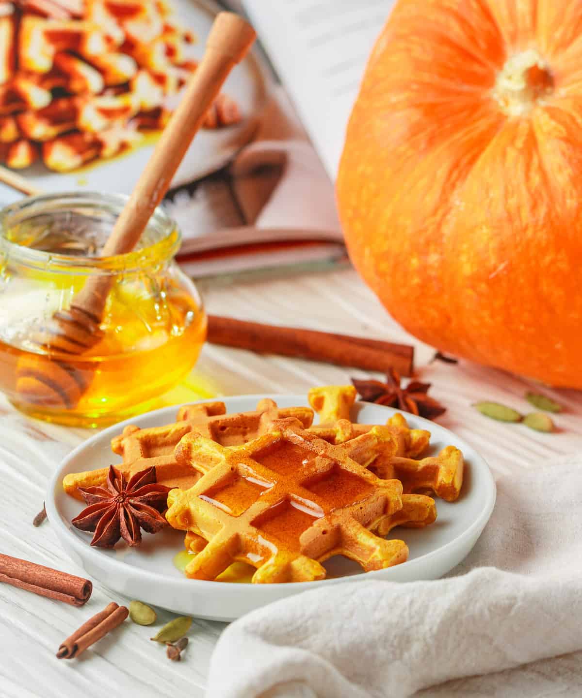 Delicious homemade healthy pumpkin spice Belgian or Viennese waffles with spices cinnamon, anise, cardamom. Served with honey. Gourmet Breakfast. The concept of home fall baking. Selective focus