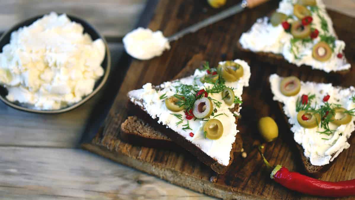 Open sandwiches with mascarpone cheese, olives and herbs. Healthy food. Keto snack.