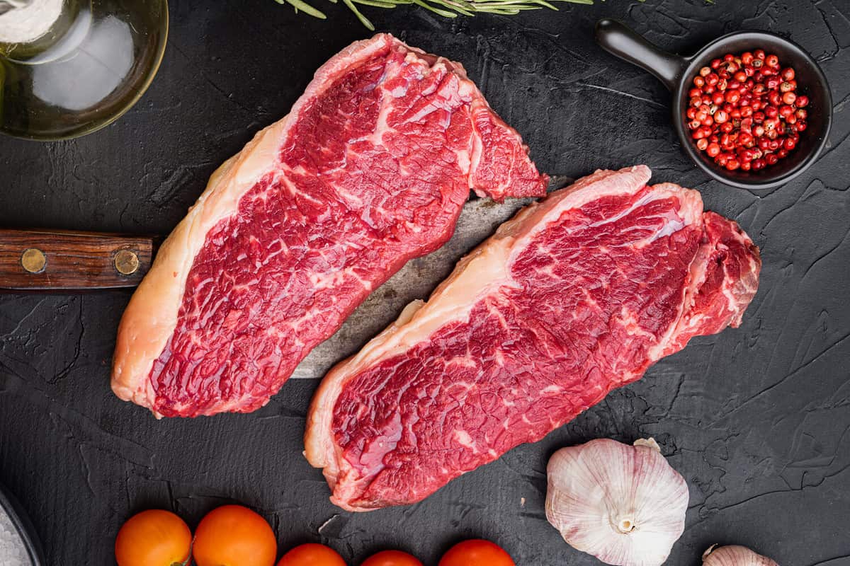 Top sirloin beef steak cut, on black background, top view