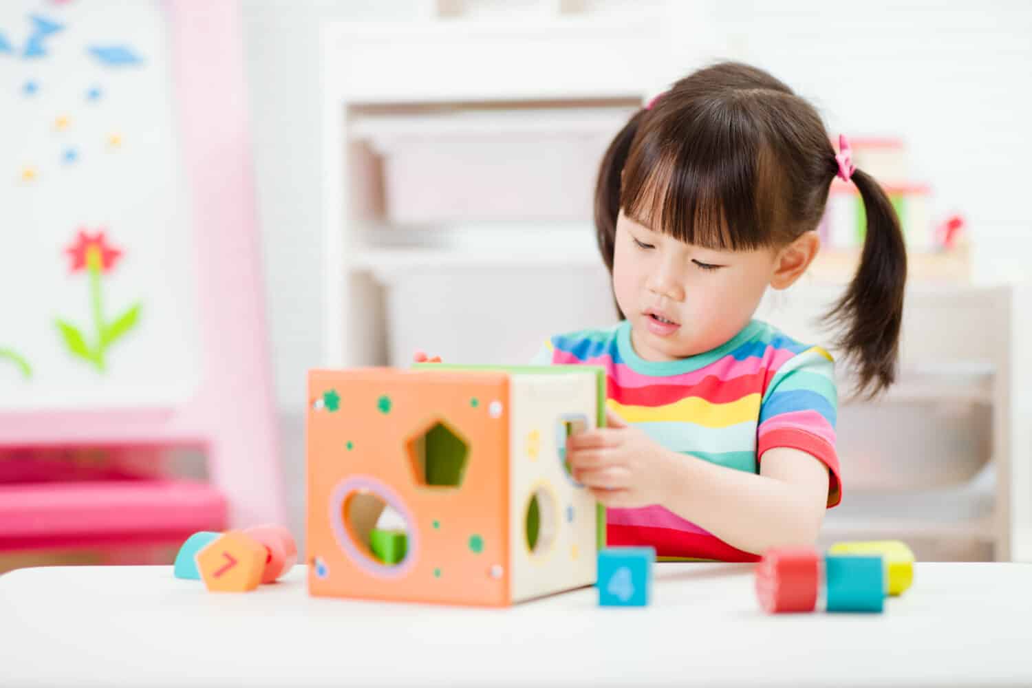 young girl playing number shape blocks for homeschooling