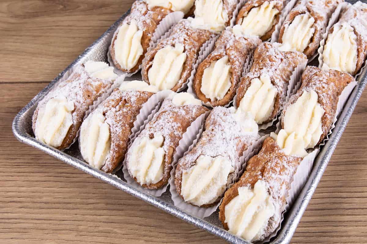 A bakery tray of creamy filled ricotta cannoli