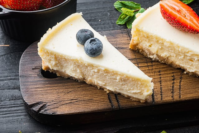 Homemade cheesecake with fresh berrie, on black wooden table background