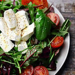 Selective focus. Delicious salad with feta cheese and cherry tomatoes. Healthy diet. A plate of salad. Spring food.