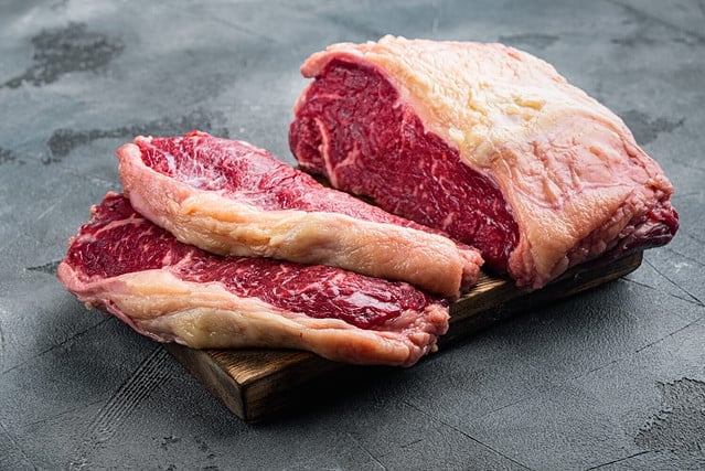 Strip steak, marbled beef raw meat, on gray background