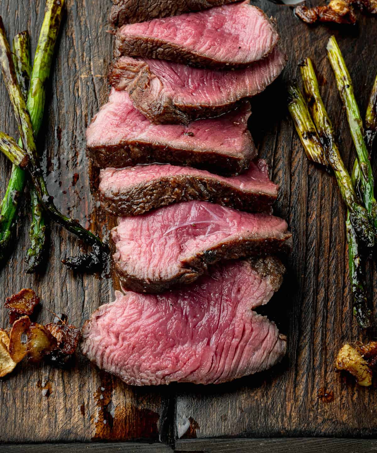 Medium rare beef steak set, tenderloin or fillet mignon cut, on wooden serving board