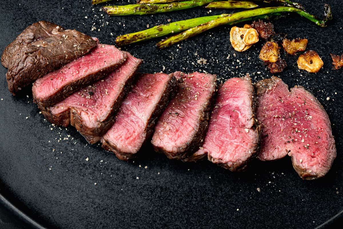 Grilled fillet mignon beef steak set, with onion and asparagus, on plate