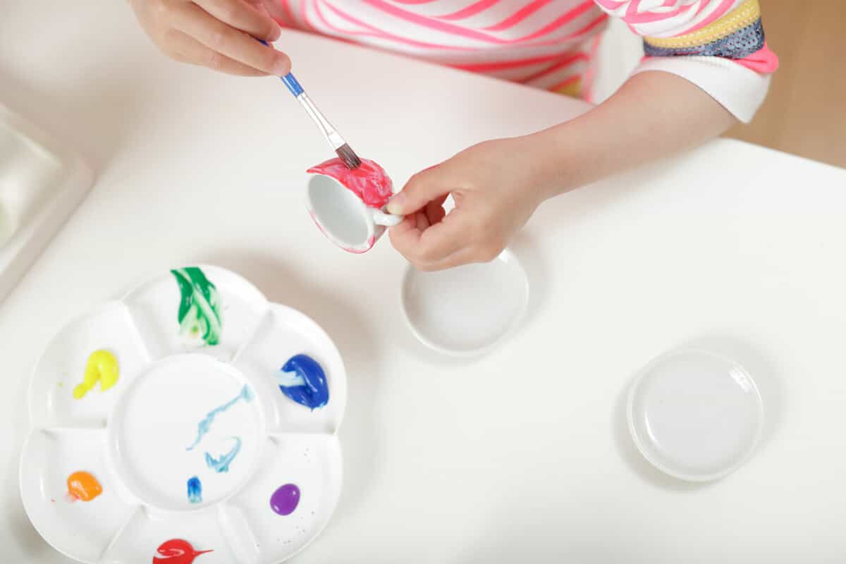 young girl painting tea set craft for homeschooling