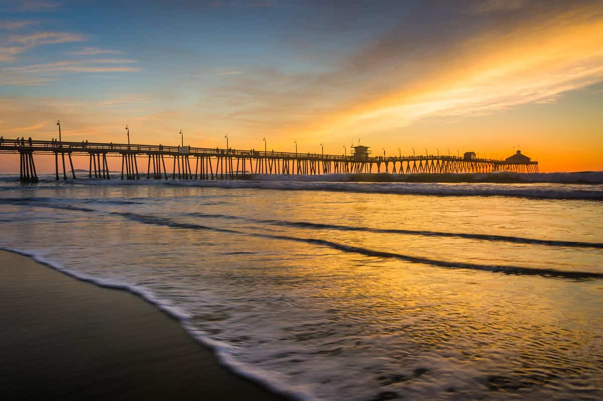 Waves in the Pacific Ocean and the fishing pier at sunset, in Imperial Beach, California.