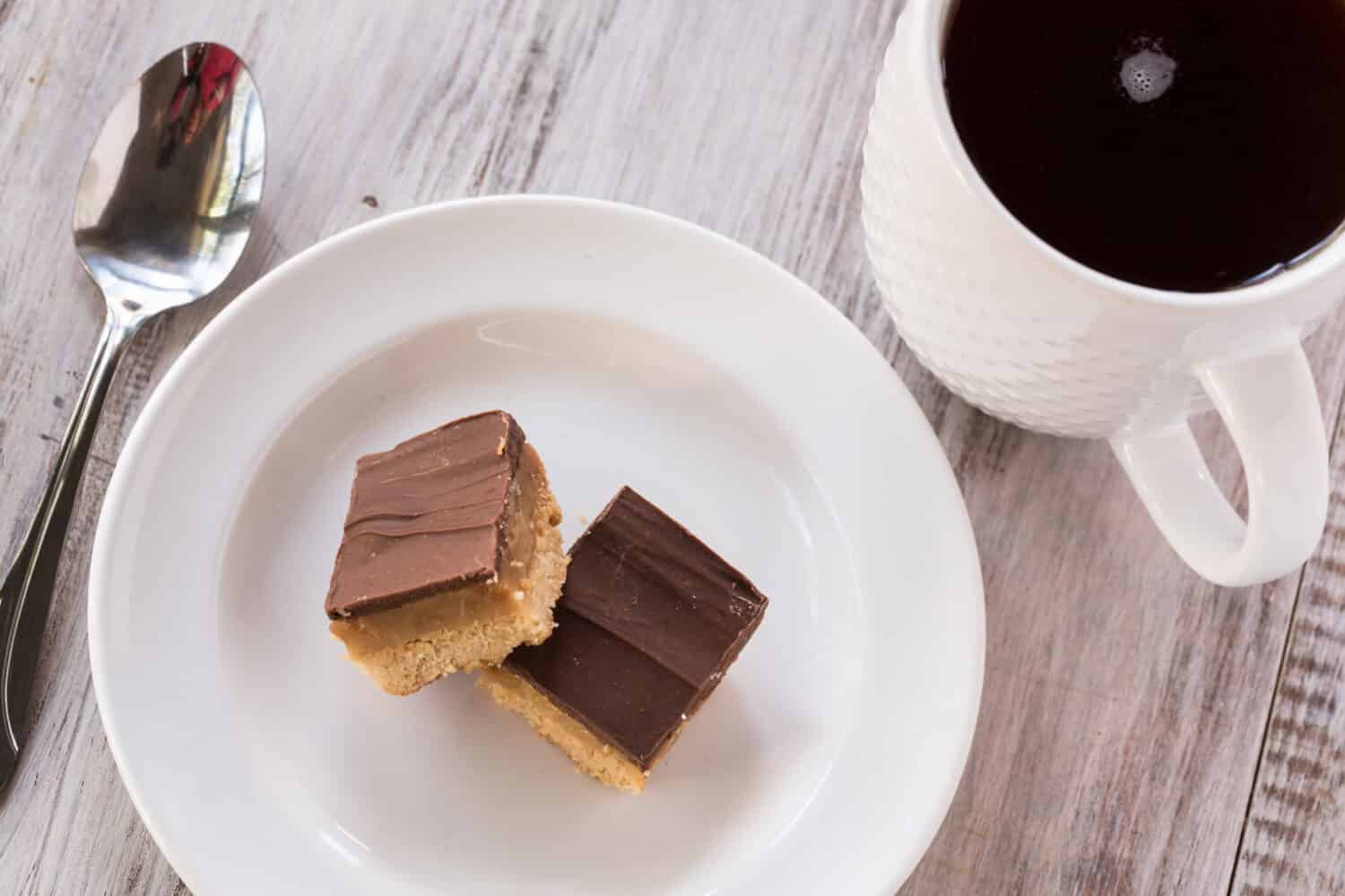 Chocolate caramel candy cookie Millionaire Bar with cup of coffee