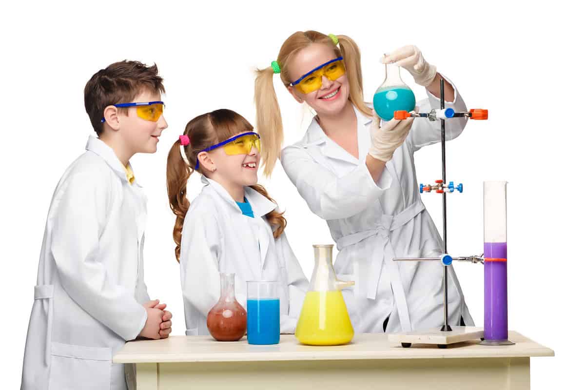 Teens and teacher of chemistry at chemistry lesson making experiments isolated on white background