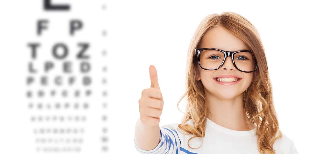education, school, childhood, people and vision concept - smiling cute little girl with black eyeglasses showing thumbs up gesture over eye chart background