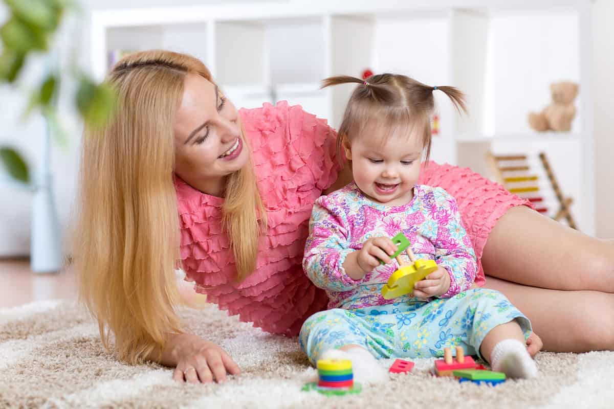 mother and her child playing with colorful puzzle toy