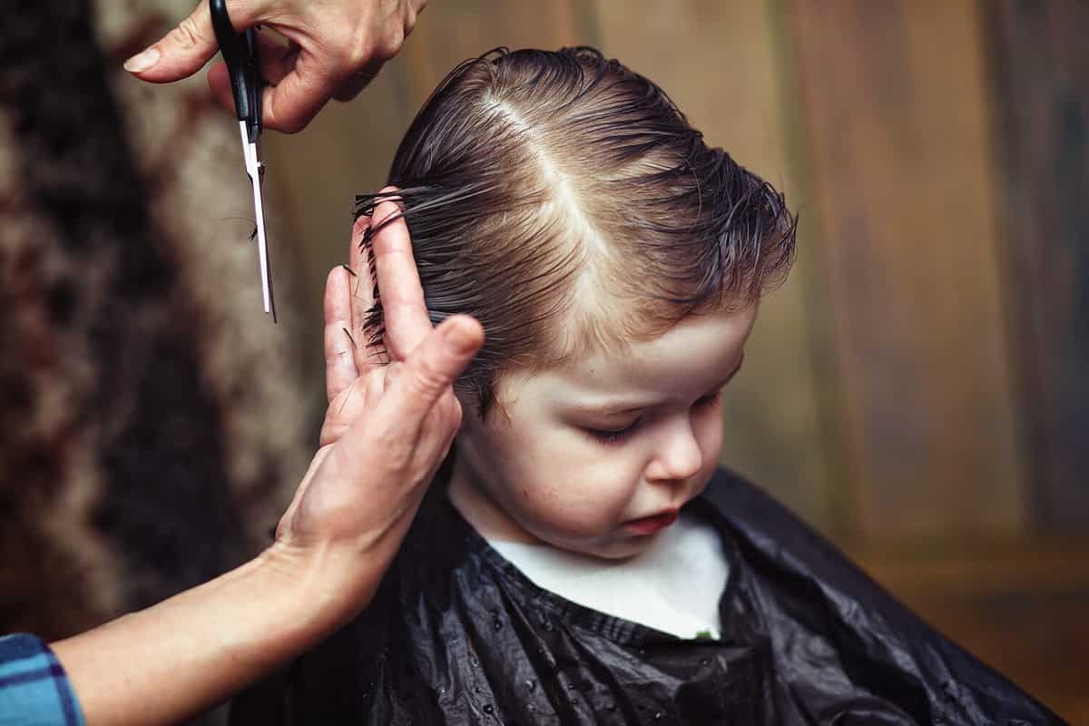 A little boy is trimmed in the hairdresser's bright emotions on his face