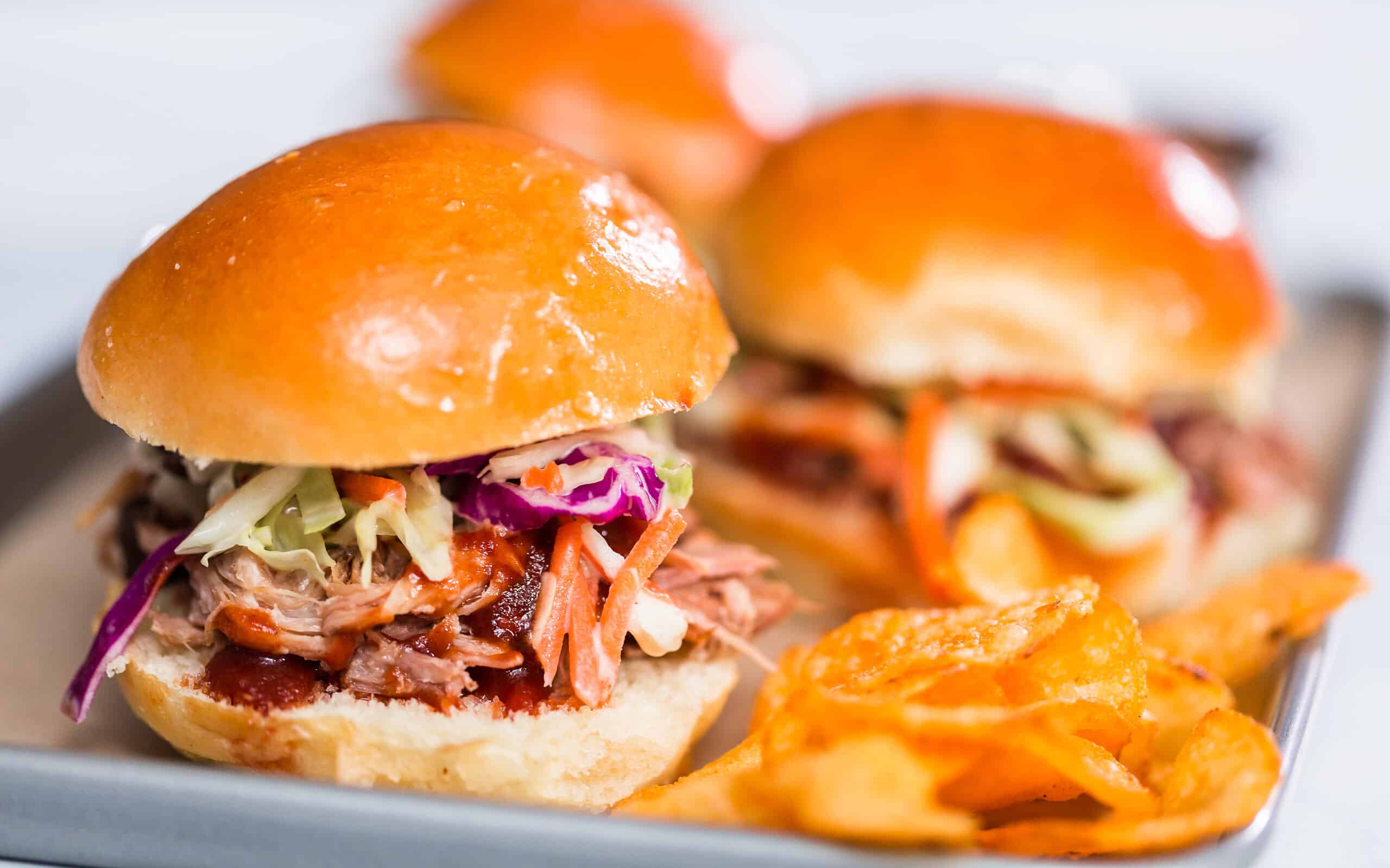 BBQ pulled pork sandwich in shape of small sliders with brioche buns.