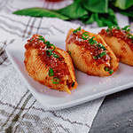 Shells pasta stuffed with a ricotta cheese, meat and basil leaves