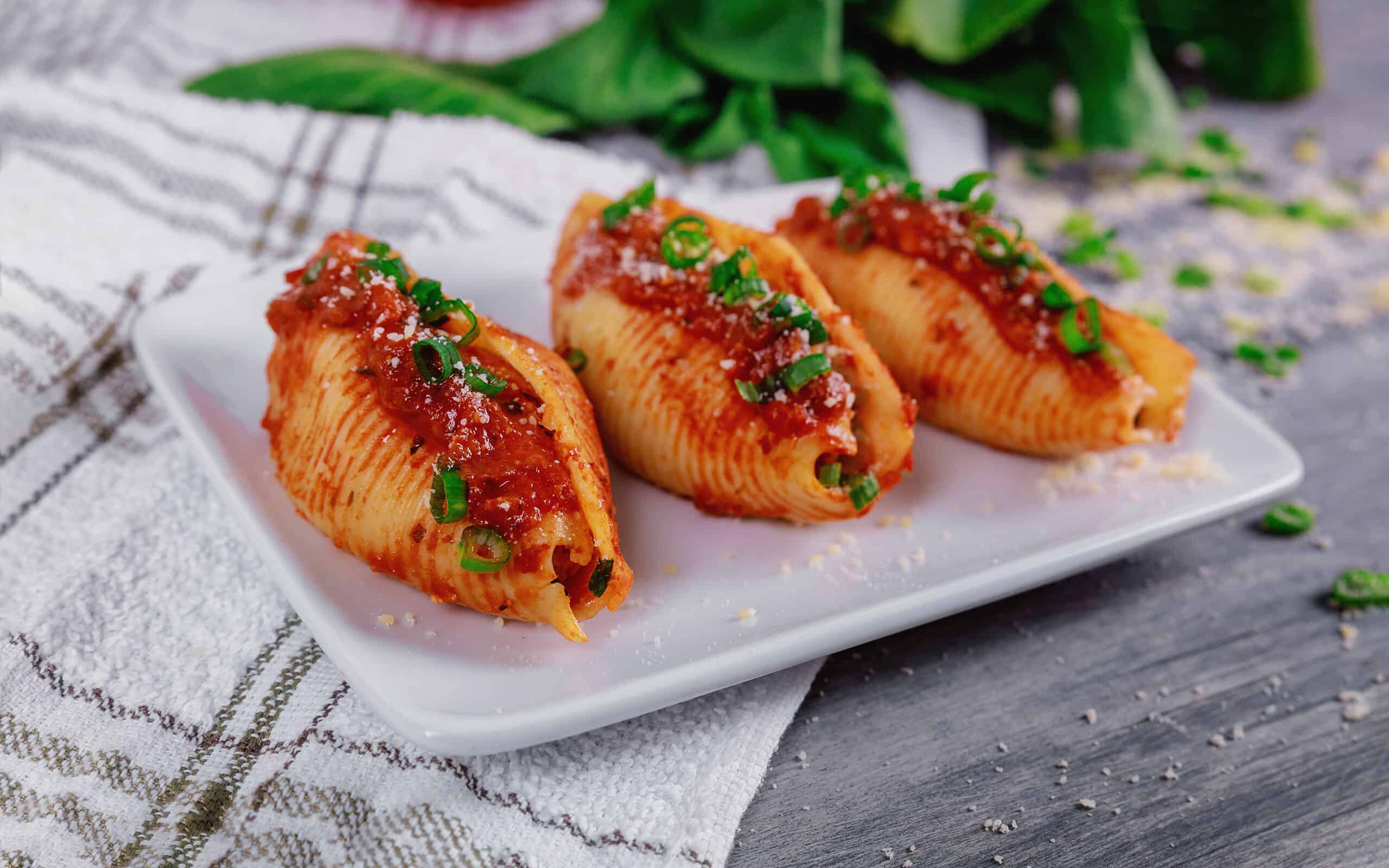 Shells pasta stuffed with a ricotta cheese, meat and basil leaves