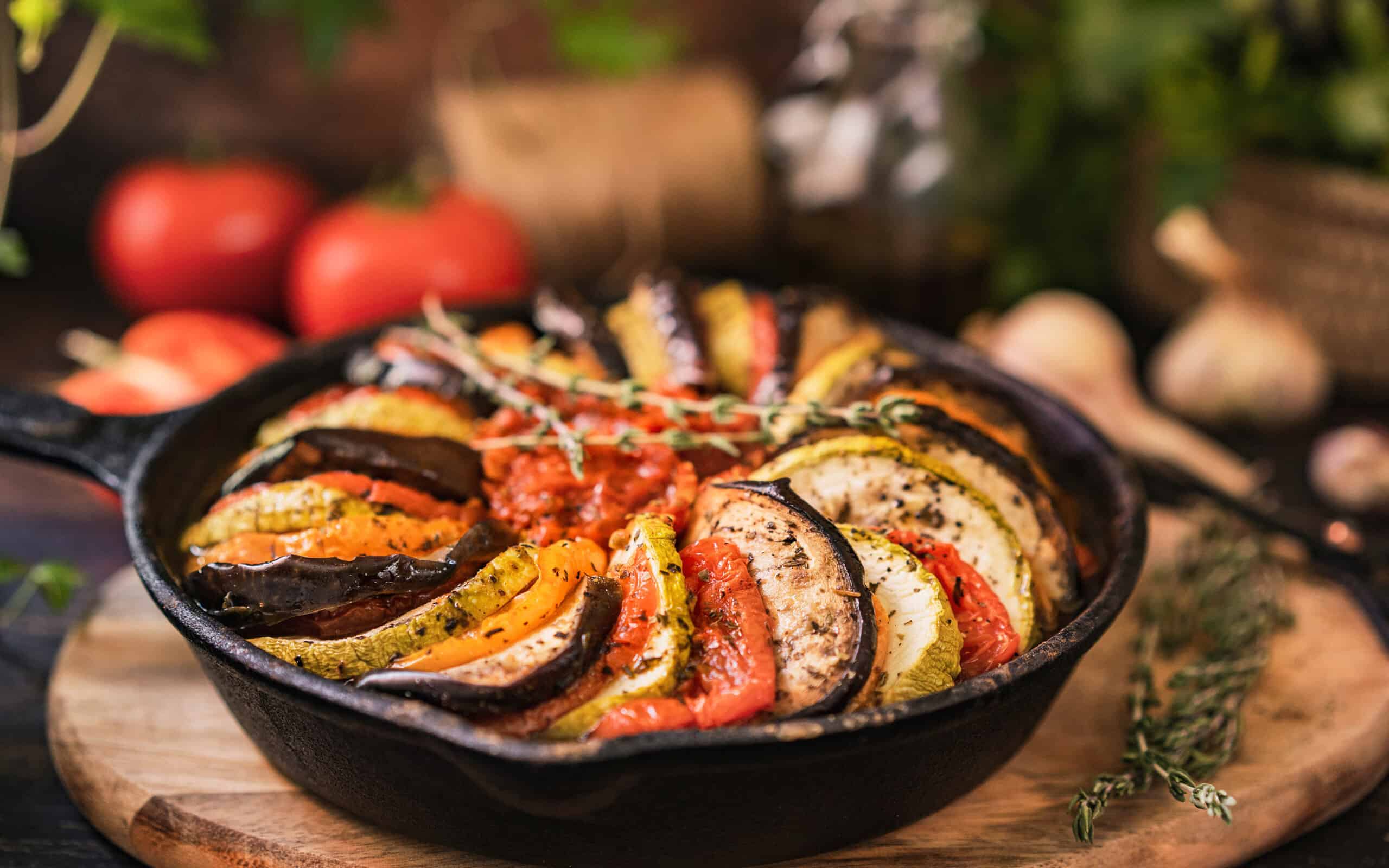 Ratatouille made of zucchini, eggplants, peppers, onions, garlic and tomatoes slices with aromatic herbs.