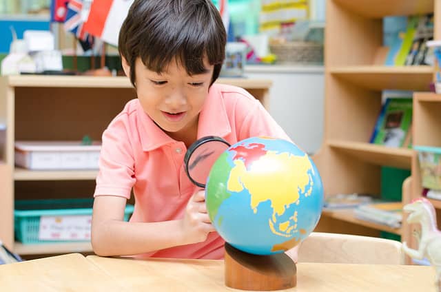 Little boy looking at Montessori globe