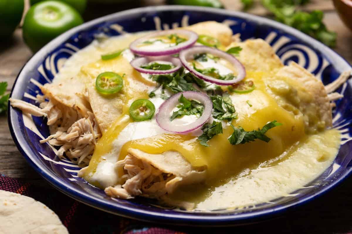 Traditional mexican green enchiladas with chicken and melted cheese