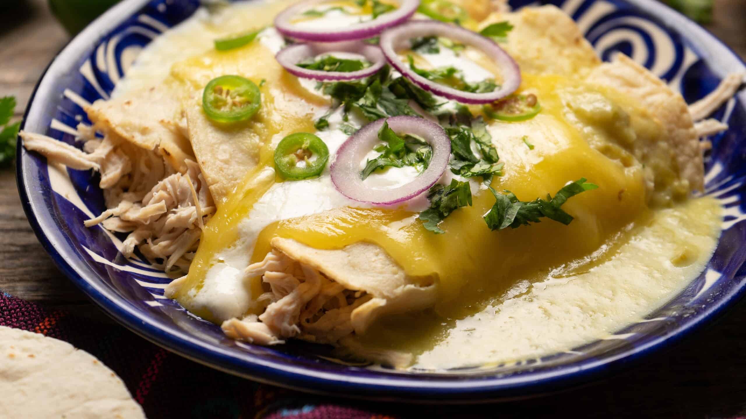 Traditional mexican green enchiladas with chicken and melted cheese