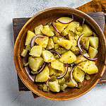 Bowl of warm potato salad with bacon, German Kartoffelsalat