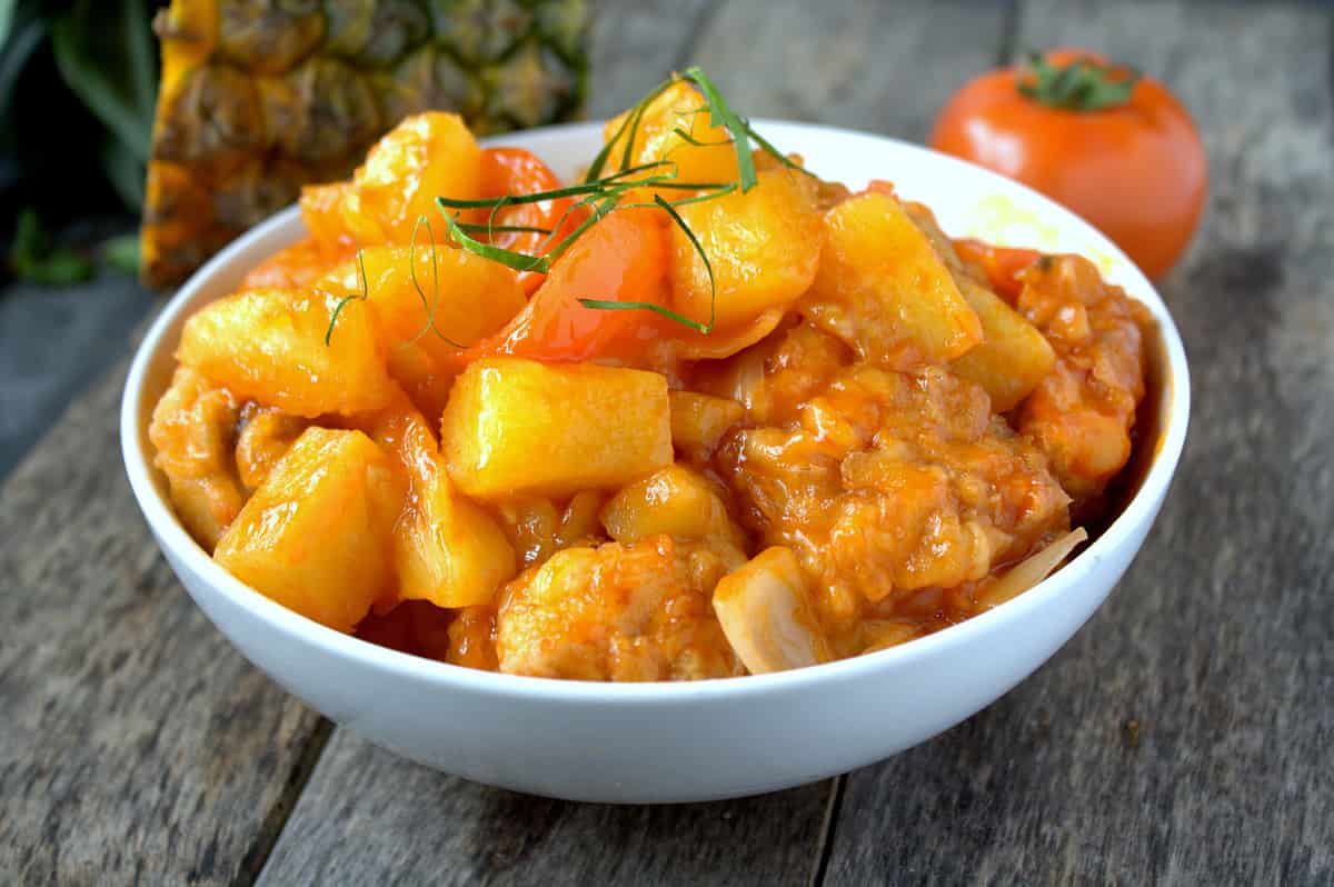 Sweet and sour chicken with pineapple and tomatoes.
