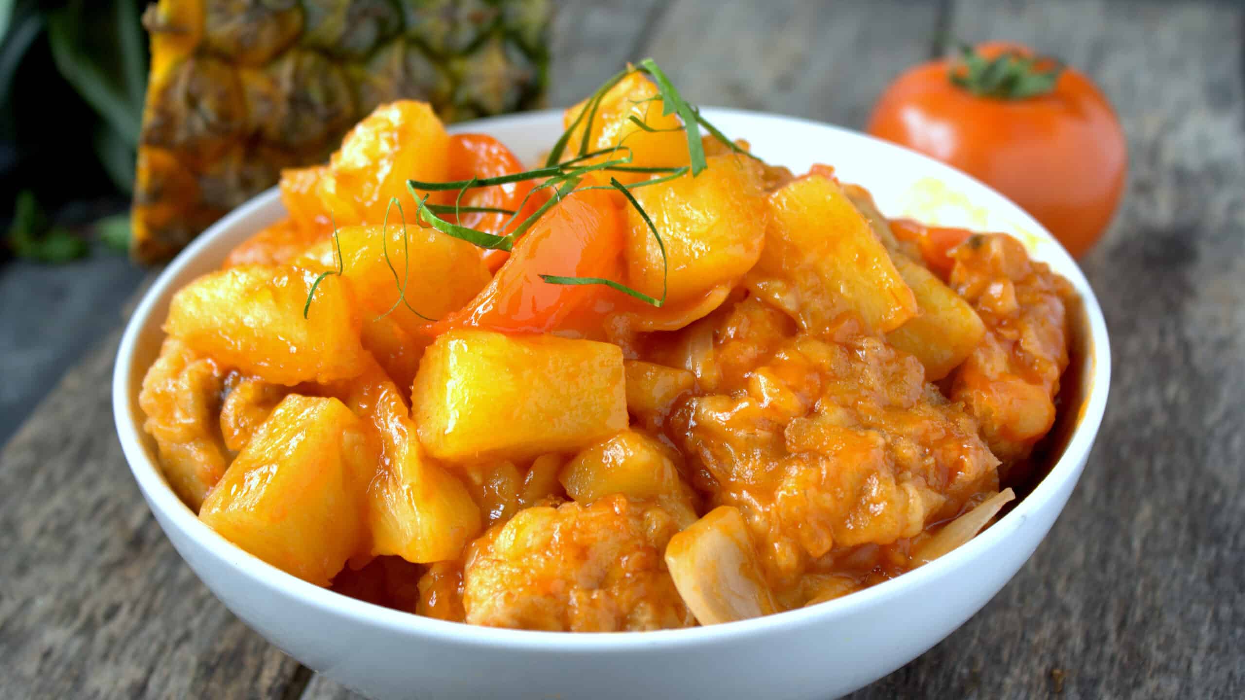 Sweet and sour chicken with pineapple and tomatoes.