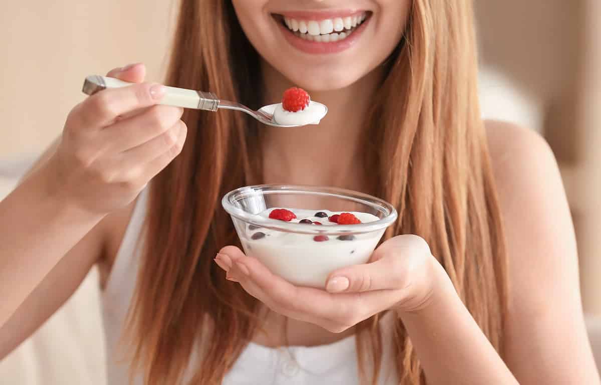 happy woman eating yogurt