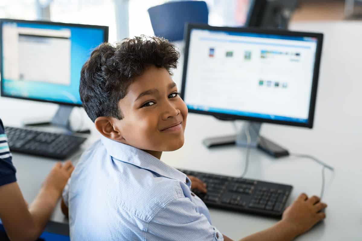 Photo of a happy Hispanic looking students using a PC.