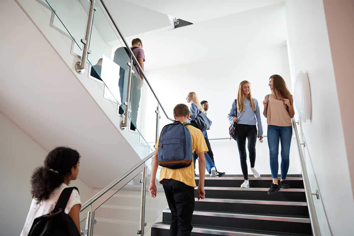 High School Students Walking On Stairs Between Lessons In Busy College Building