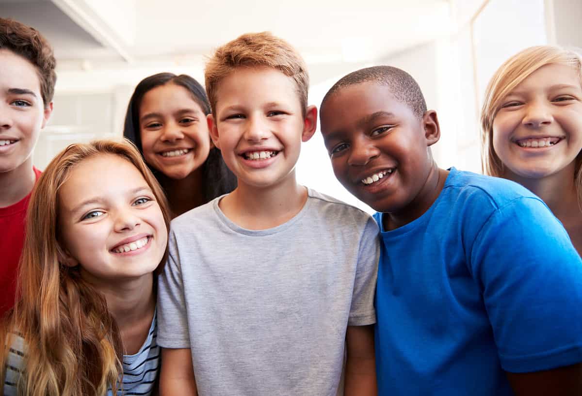 Group of happy smiling school children looking at the camera.