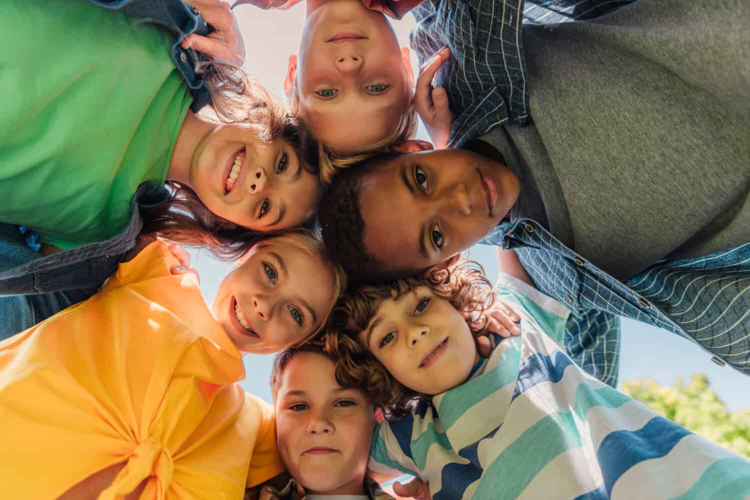 bottom view of happy multicultural kids looking at camera