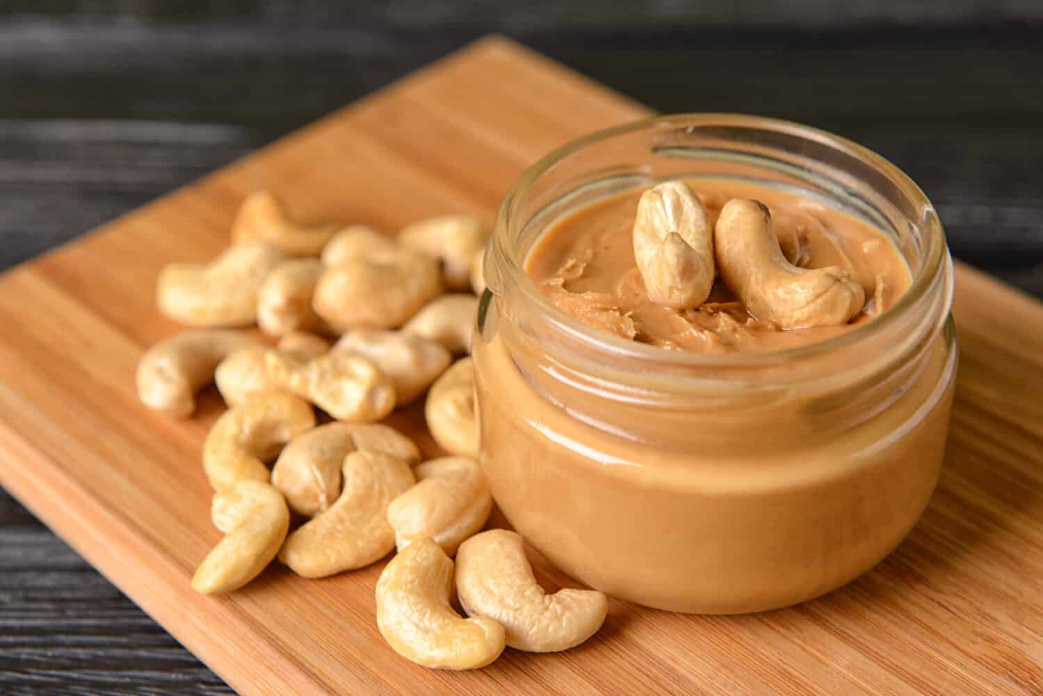 Jar of cashew butter on wooden table