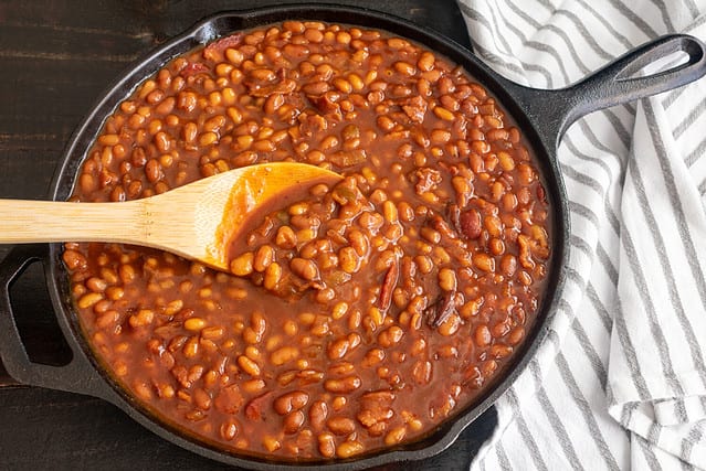 Bourbon Baked Beans in a Cast Iron Skillet: Pork and beans seasoned with bourbon whiskey, molasses, and brown sugar