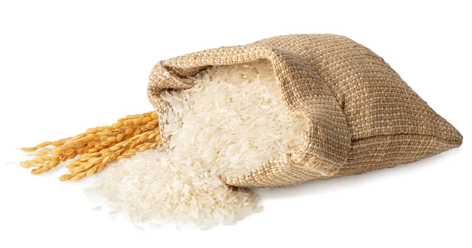 A close-up of a burlap sack filled with long grain rice.
