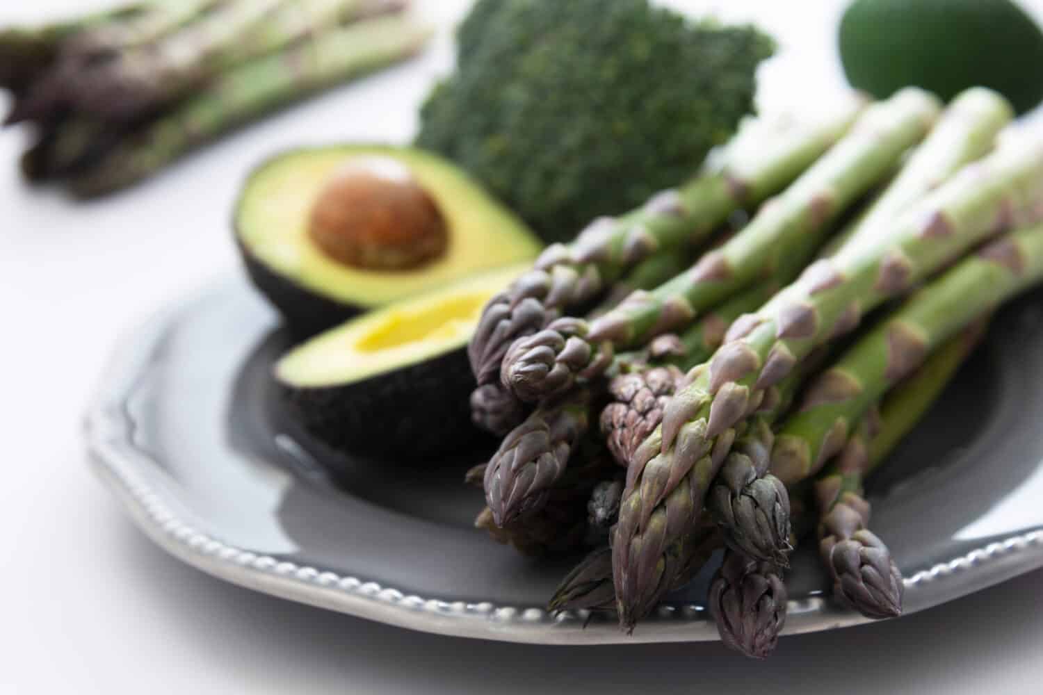 Green vegetables - asparagus, avocado and broccoli. Fresh vegetable mix. Healthy eating concept.