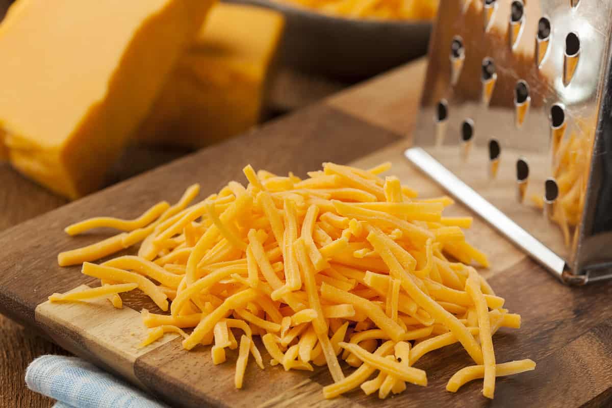 Organic Shredded Sharp Cheddar Cheese on a Cutting Board