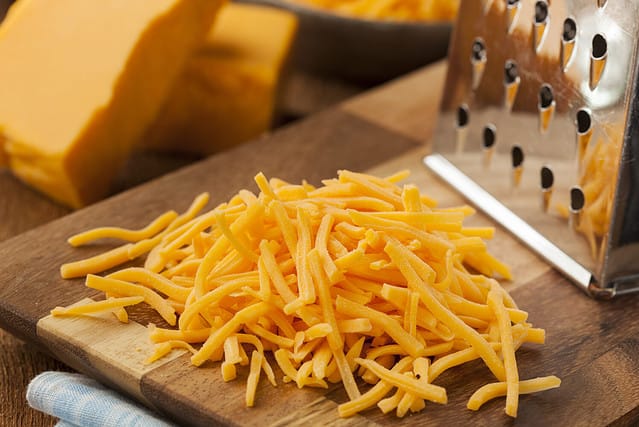 Organic Shredded Sharp Cheddar Cheese on a Cutting Board